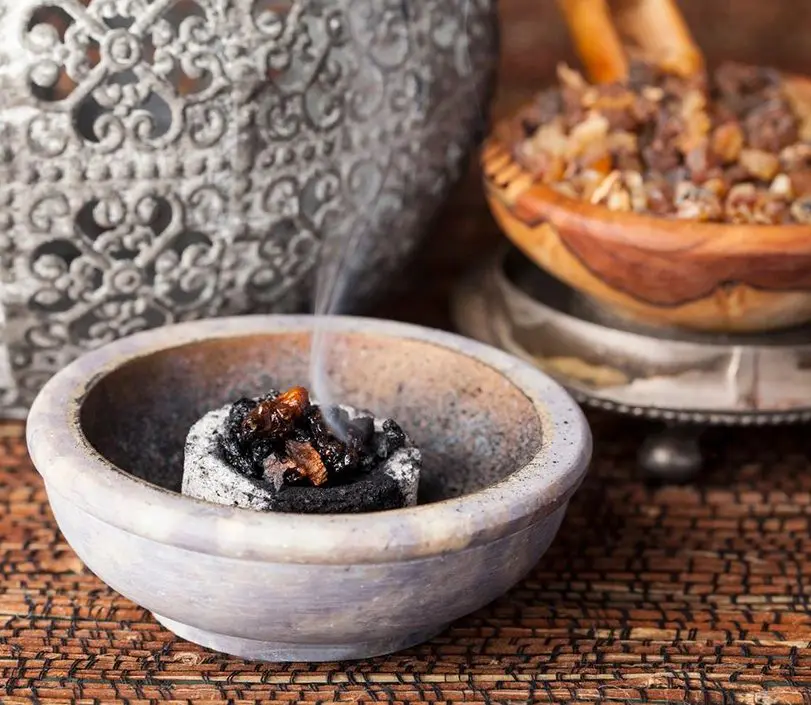 A bowl of incense and a bowl of nuts