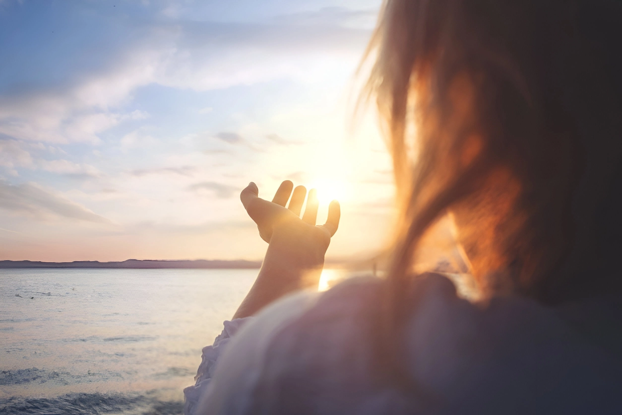 A person holding their hand out to the sun